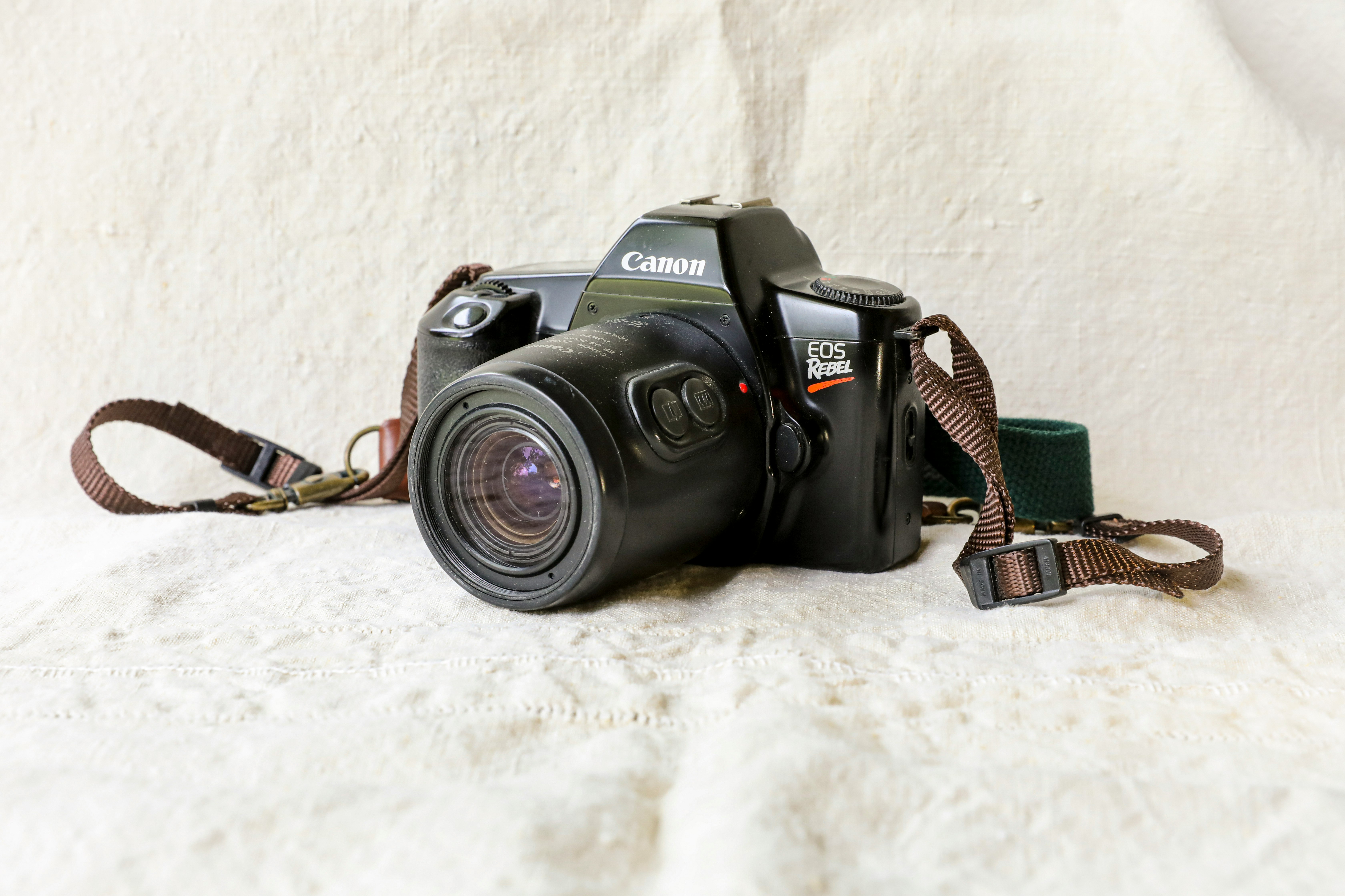 black nikon dslr camera on white textile